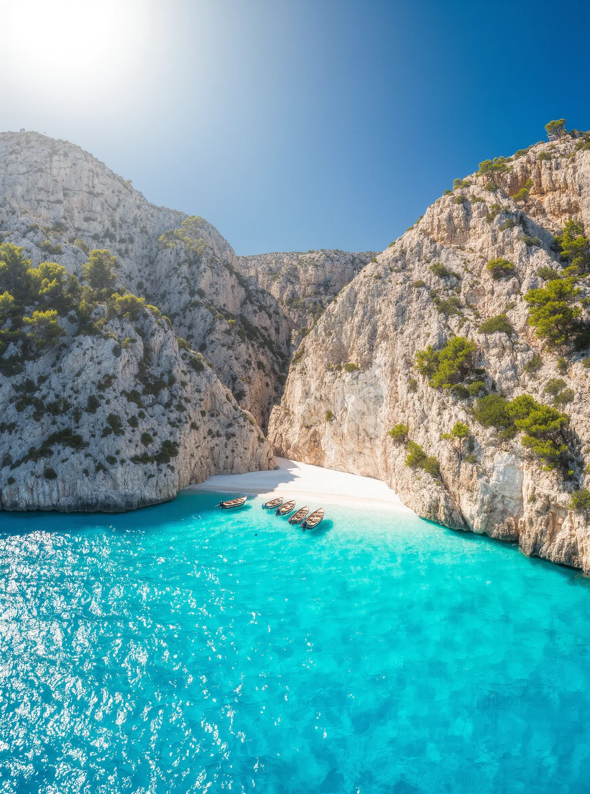 Helle Bucht auf Mallorca mit Booten am Sandstrand und türkisem Wasser